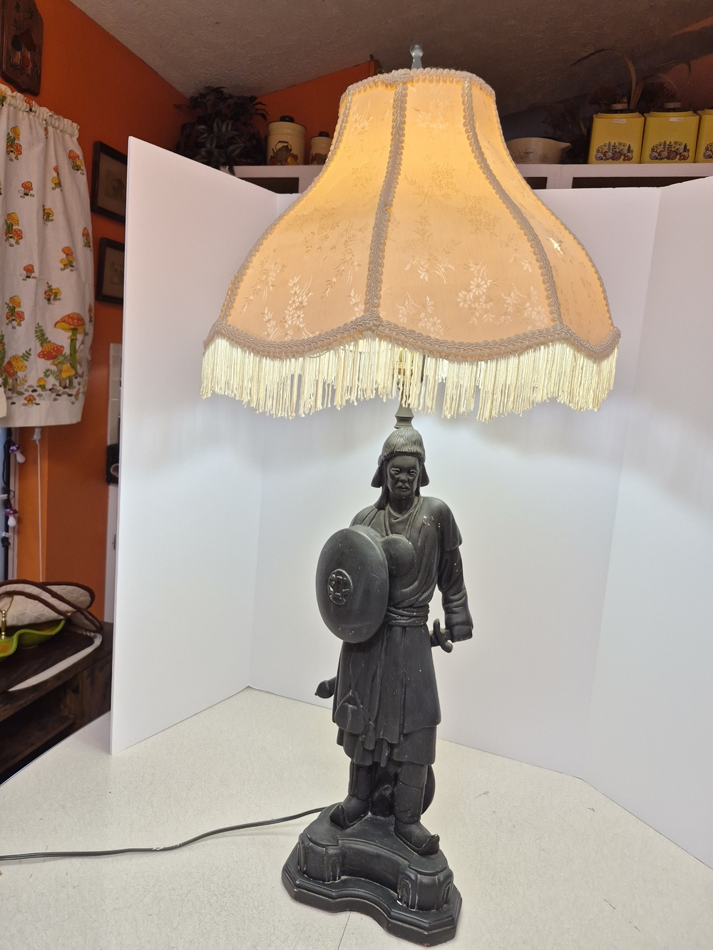 Vintage Black Warrior Lamp with Beige Fabric Shade and Fringe Trim